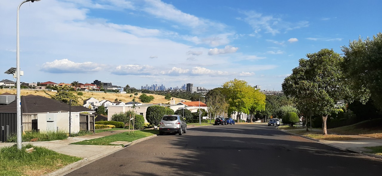 Avondale Heights, VIC, Residential street with city skyline in distance