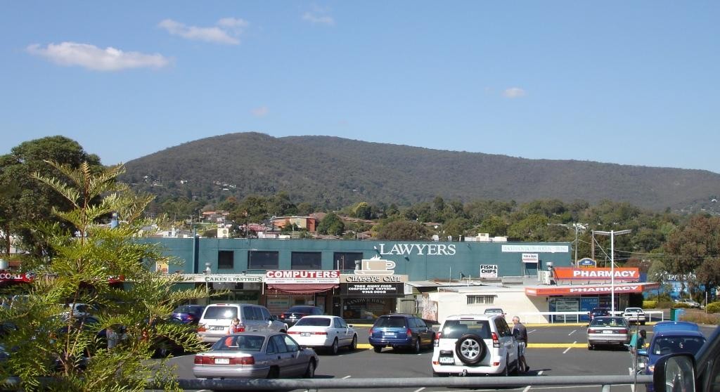 Boronia, VIC, Shopfronts and parking lot with mountain backdrop