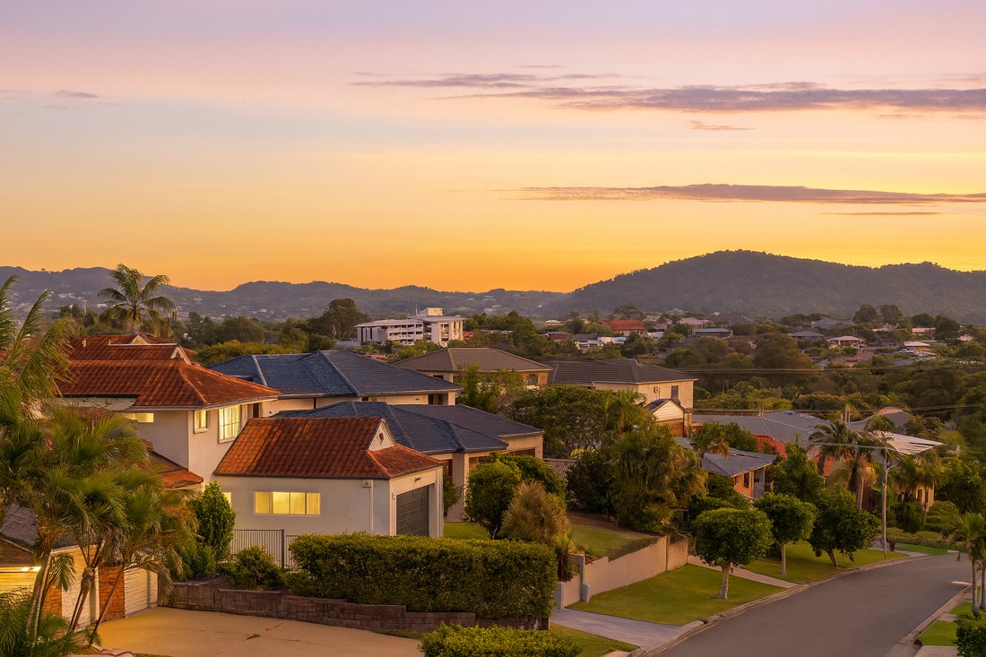 Carindale, QLD, Residential houses with surrounding hills at sunset