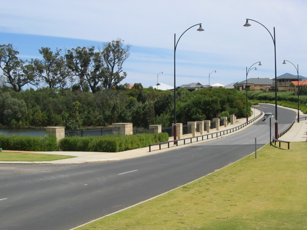 Dalyellup, WA, Curved road with street lamps and parkland