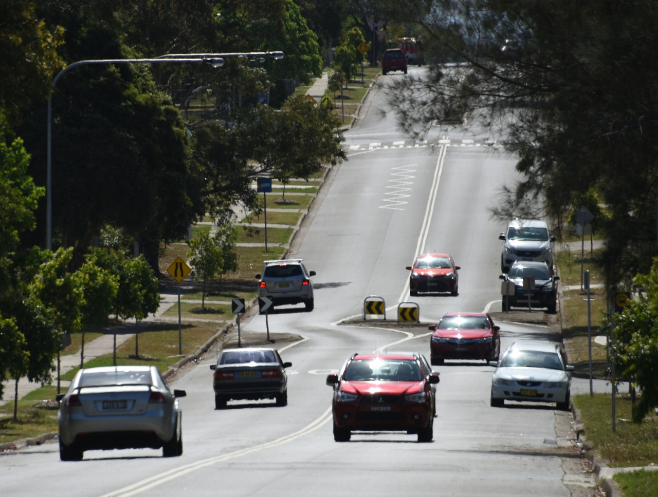 Doonside, NSW, Cars driving on a tree-lined suburban street
