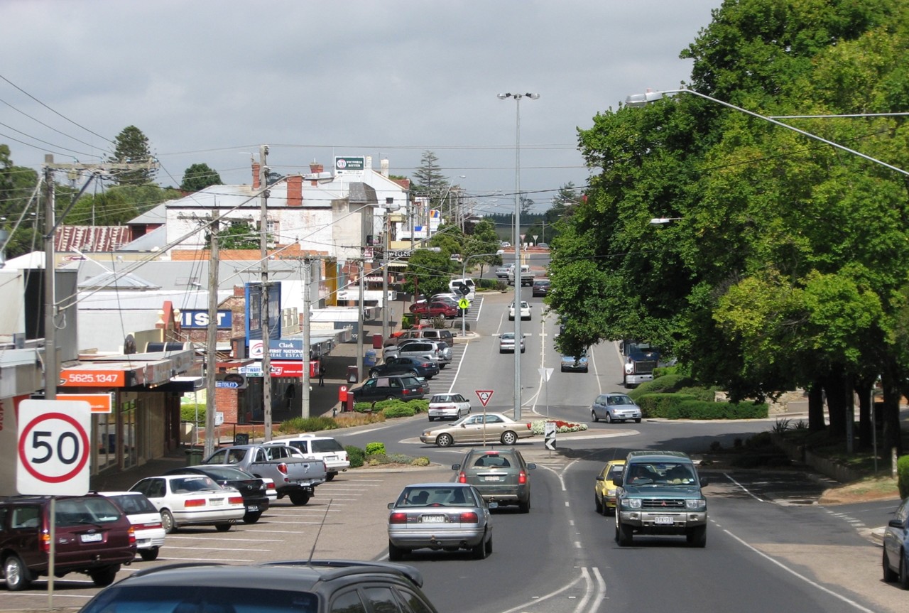 Drouin, VIC, Commercial street with shops and parked cars