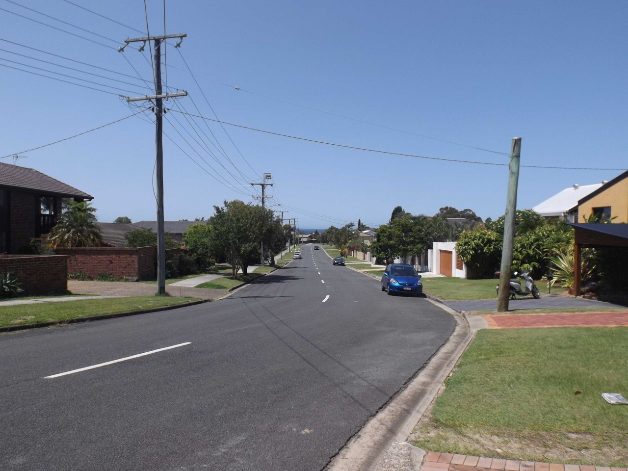 Elanora, QLD, Suburban street with houses and power lines