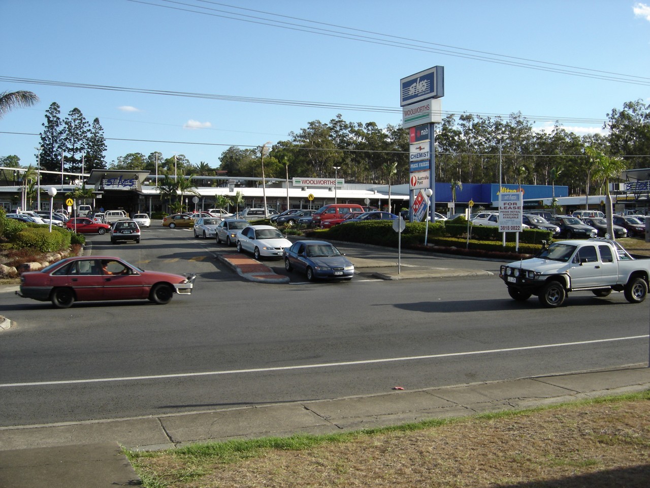 Goodna, QLD, Cars and shops at a busy intersection