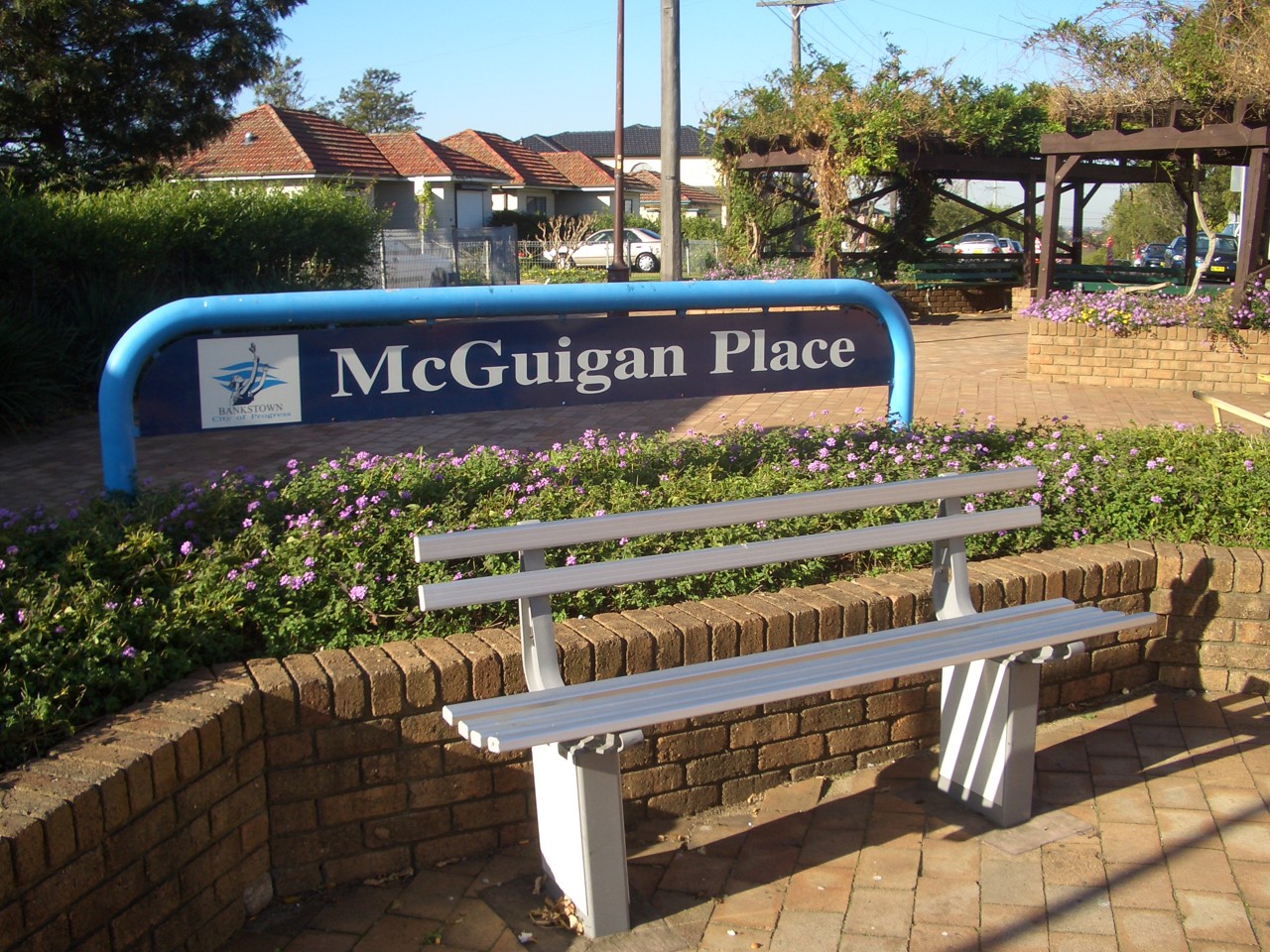 Greenacre, NSW, McGuigan Place sign and bench seating