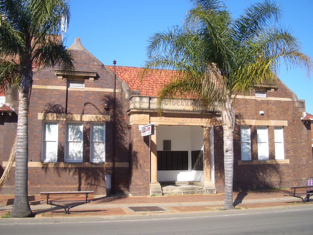 Lidcombe, NSW, Red brick building with palm trees in front