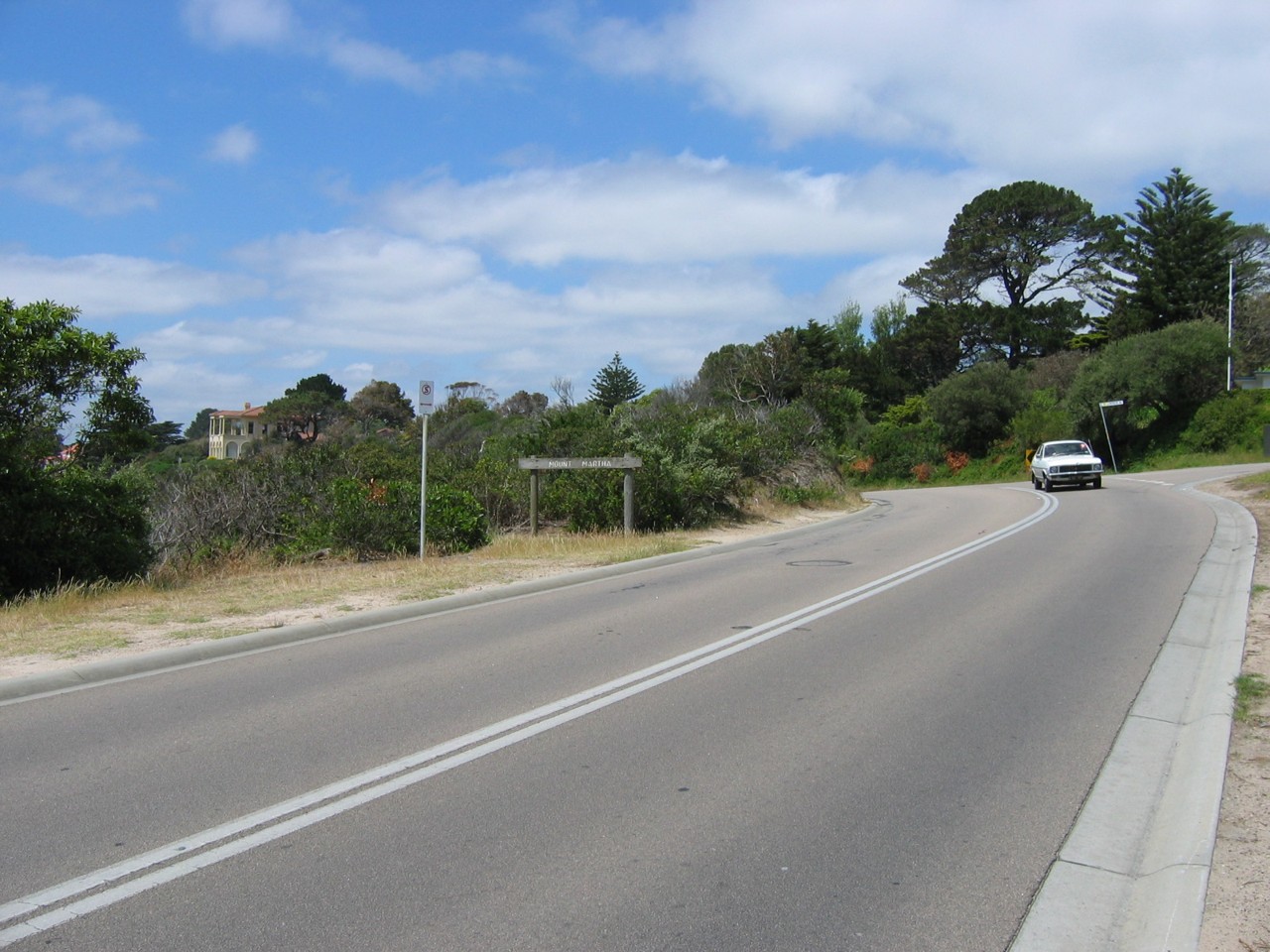 Mount Martha, VIC, Curved road with car and trees nearby