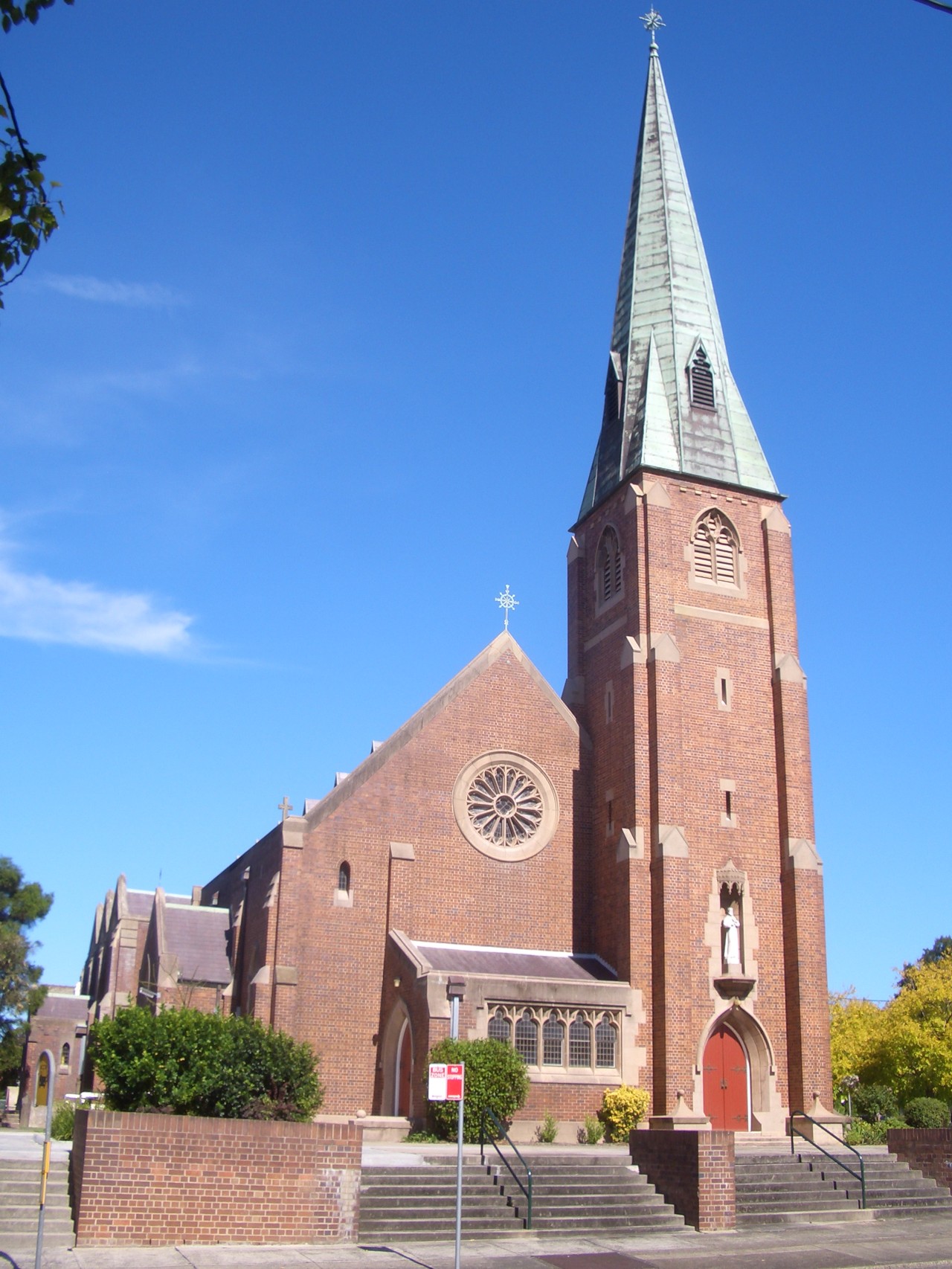 Naremburn, NSW, Brick church with tall spire and steps