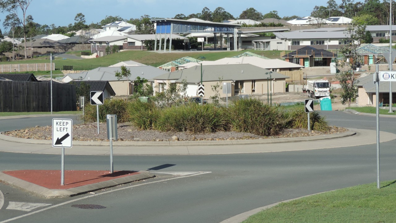 Ormeau, QLD, Residential area with roundabout and road signs