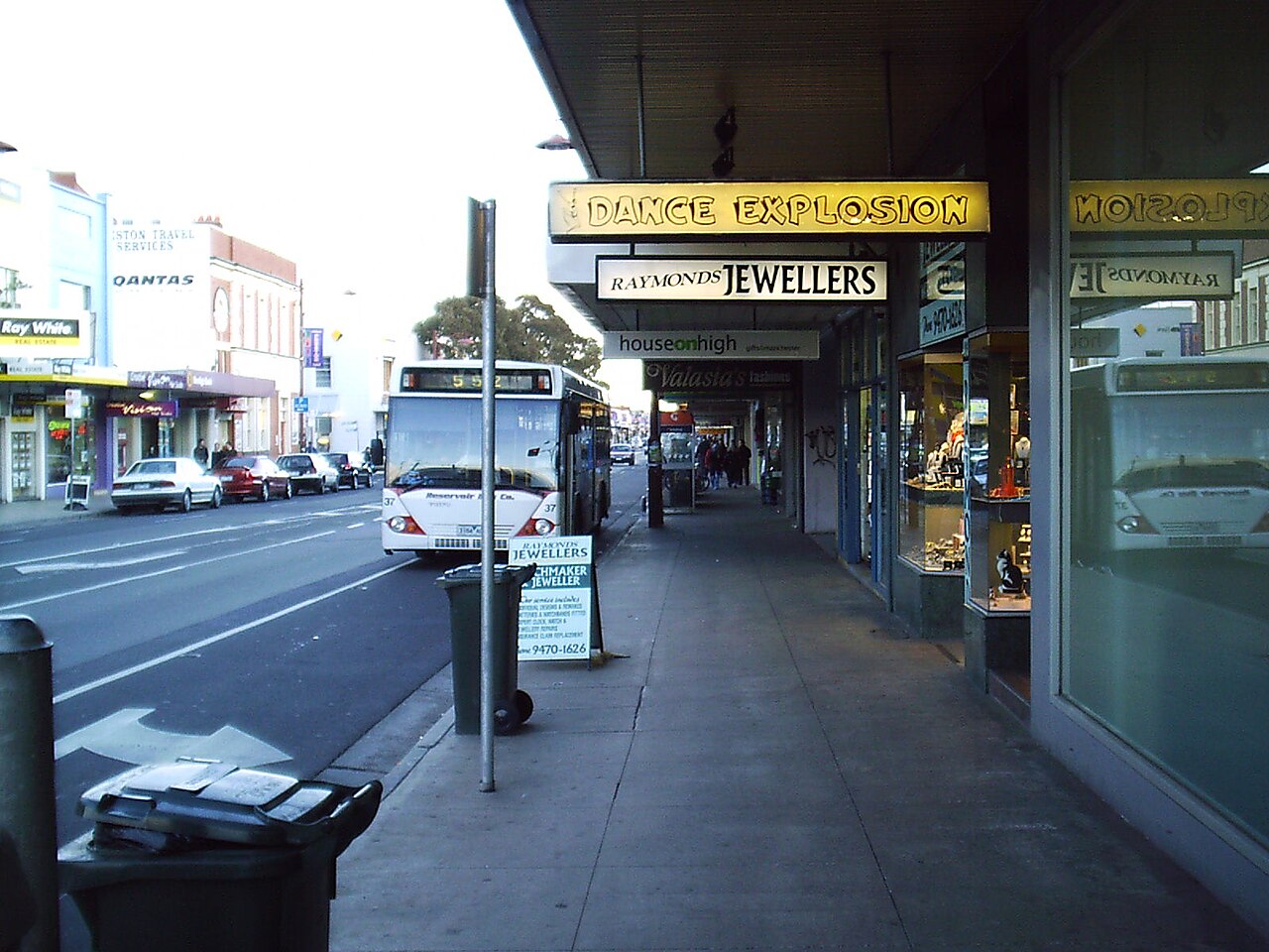 Preston, VIC, Shopfronts and bus on a commercial street