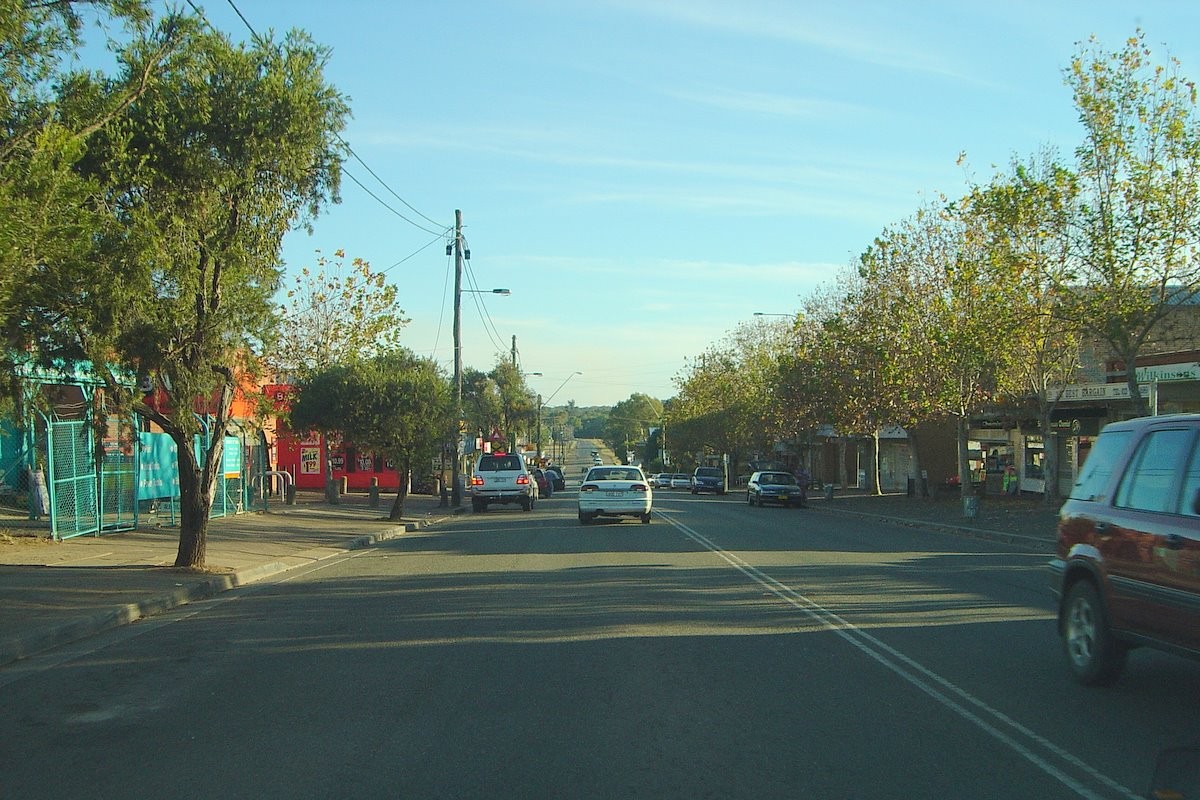 Riverstone, NSW, Empty road with parked cars and trees