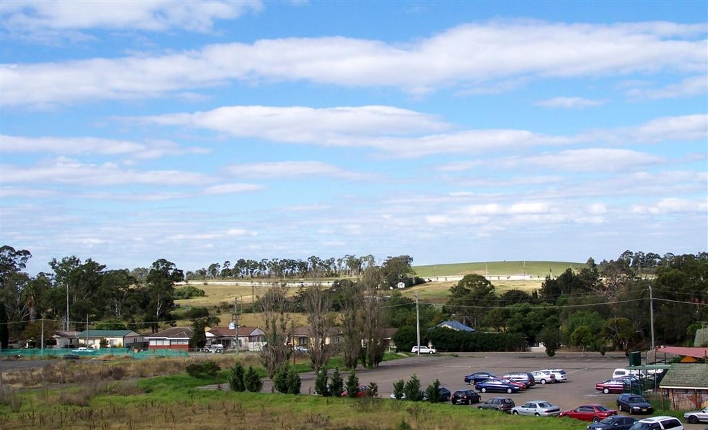 Rooty Hill, NSW, Open field with parked cars and trees