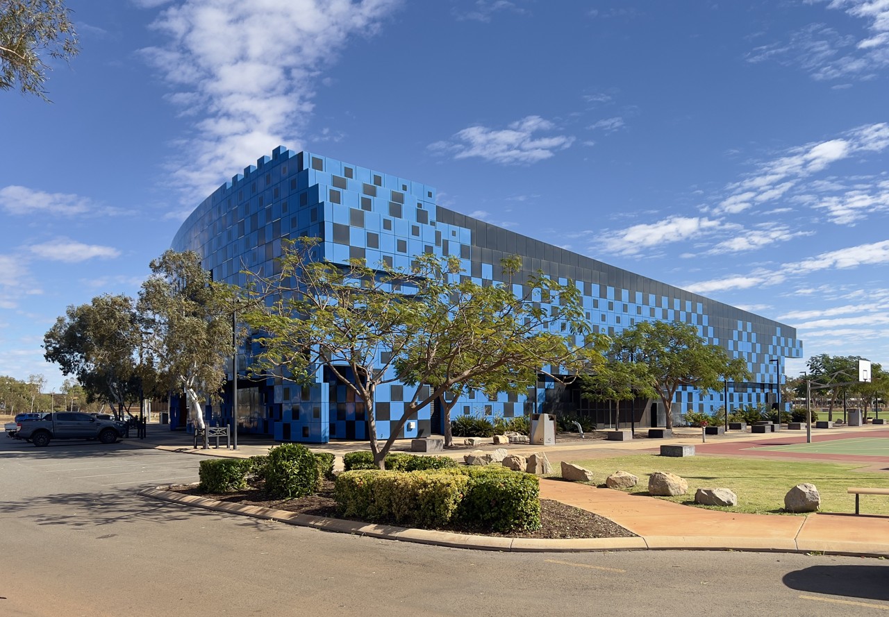 South Hedland, WA, Blue checkered building with trees and road