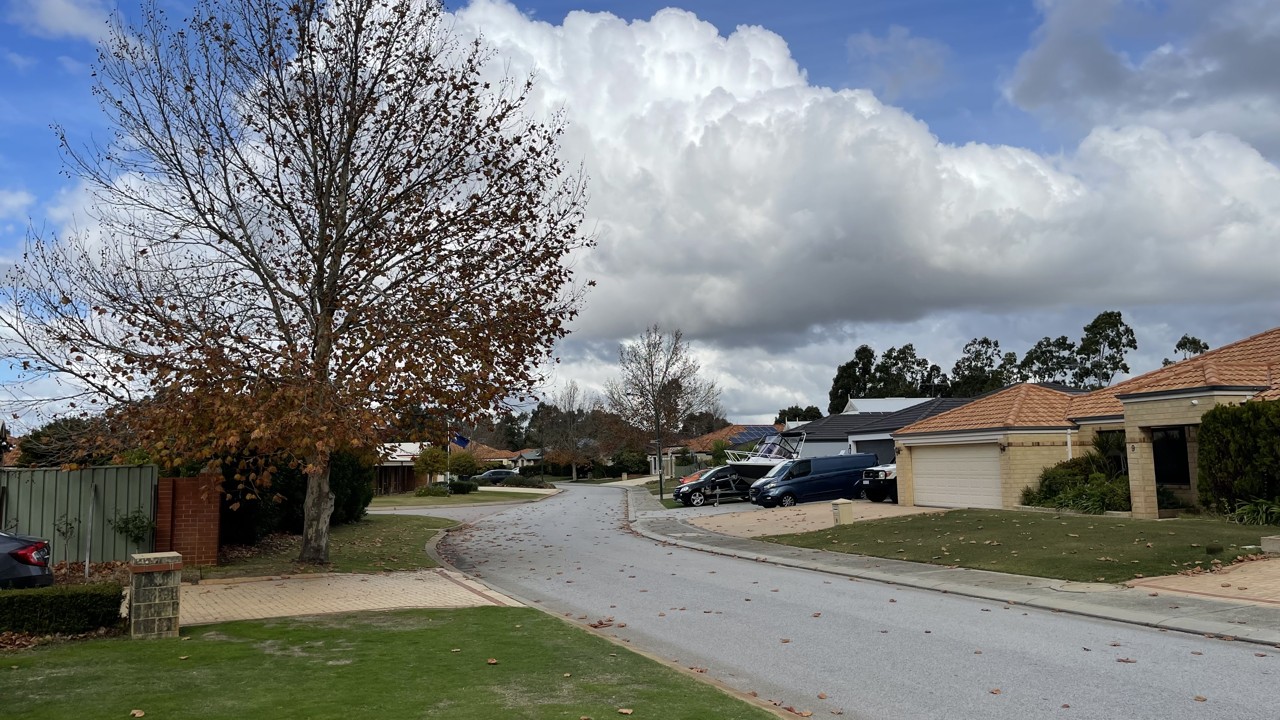 Southern River, WA, Suburban street with houses and parked cars