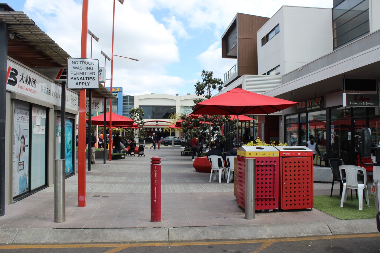 Springvale, VIC, Outdoor seating area with red umbrellas and shops