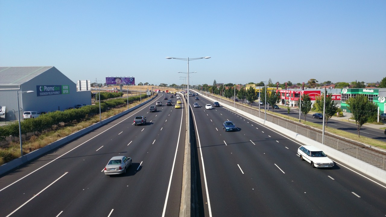 Tullamarine, VIC, Cars on the Tullamarine Freeway with buildings