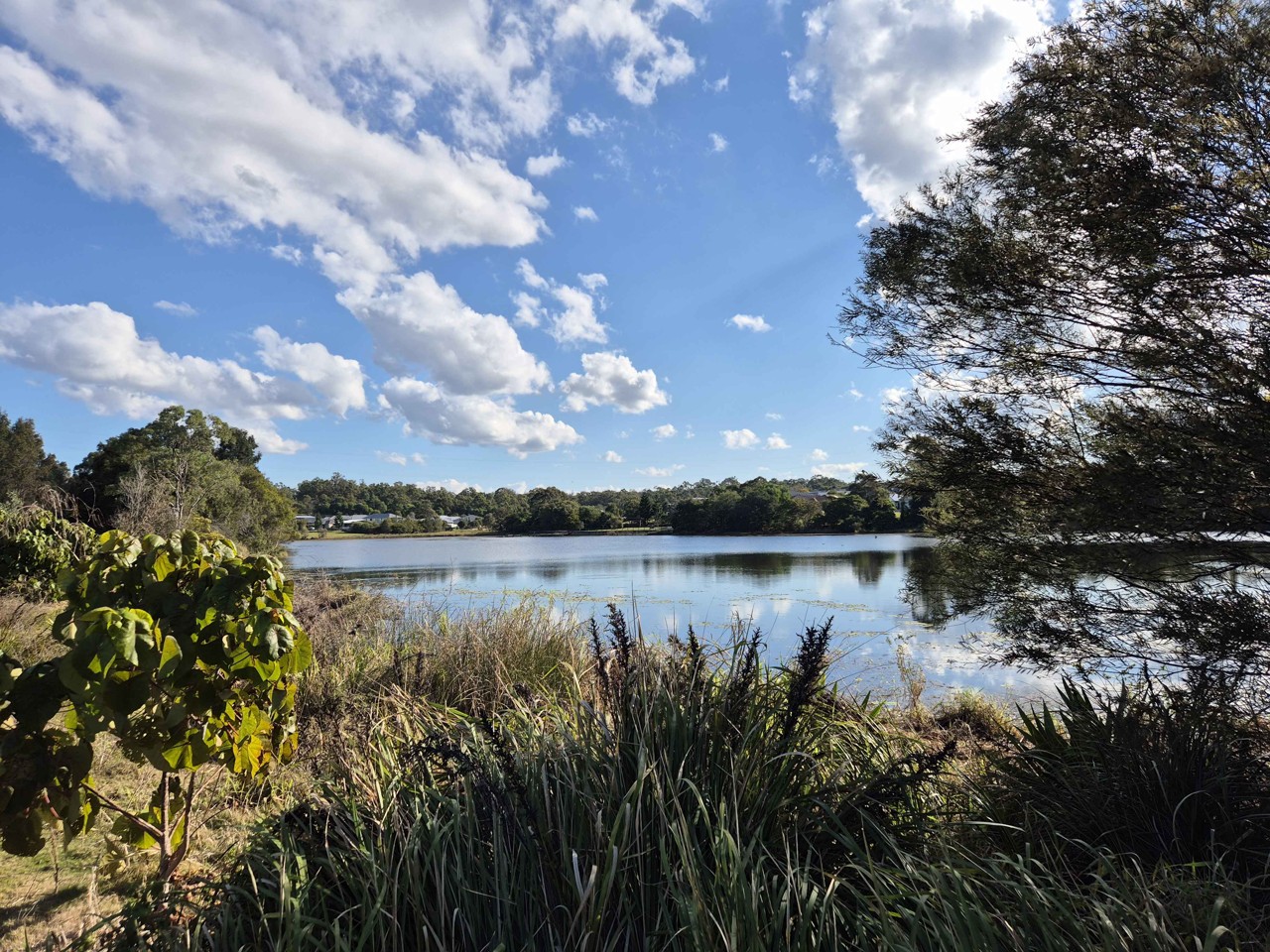 Warner, QLD, Lakeside view with trees and cloudy sky