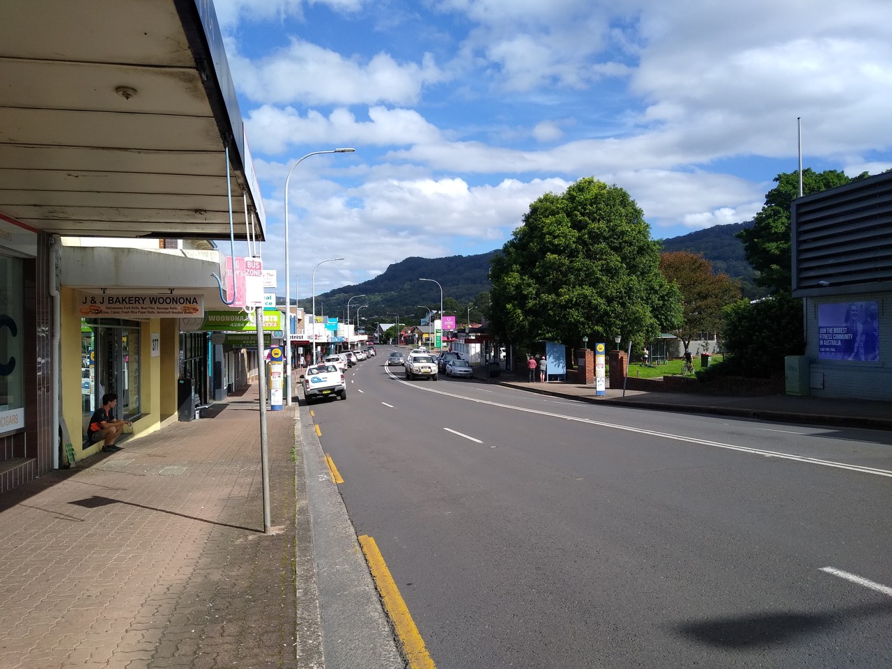 Woonona, NSW, Shops and street with mountain backdrop