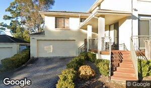 A detached two-storey home with a double garage, front steps and a landscaped entrance.