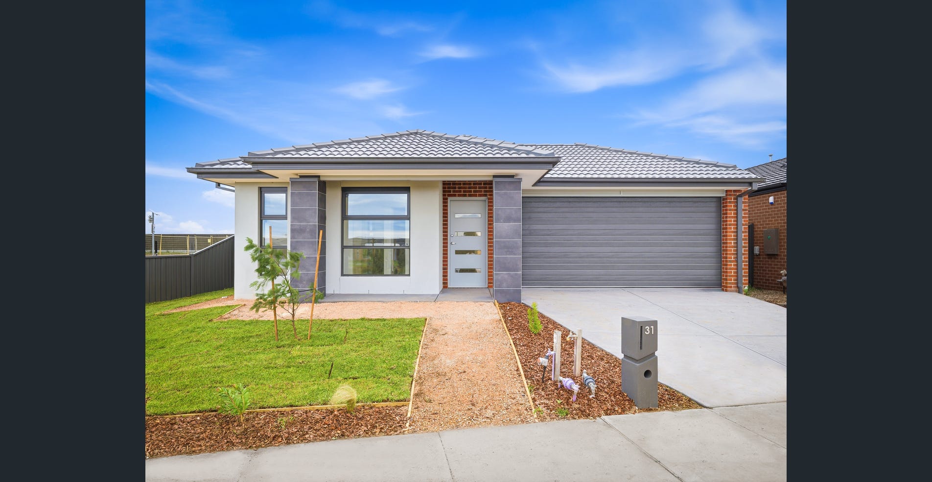 A single-storey home with a double garage, driveway and a small front lawn.