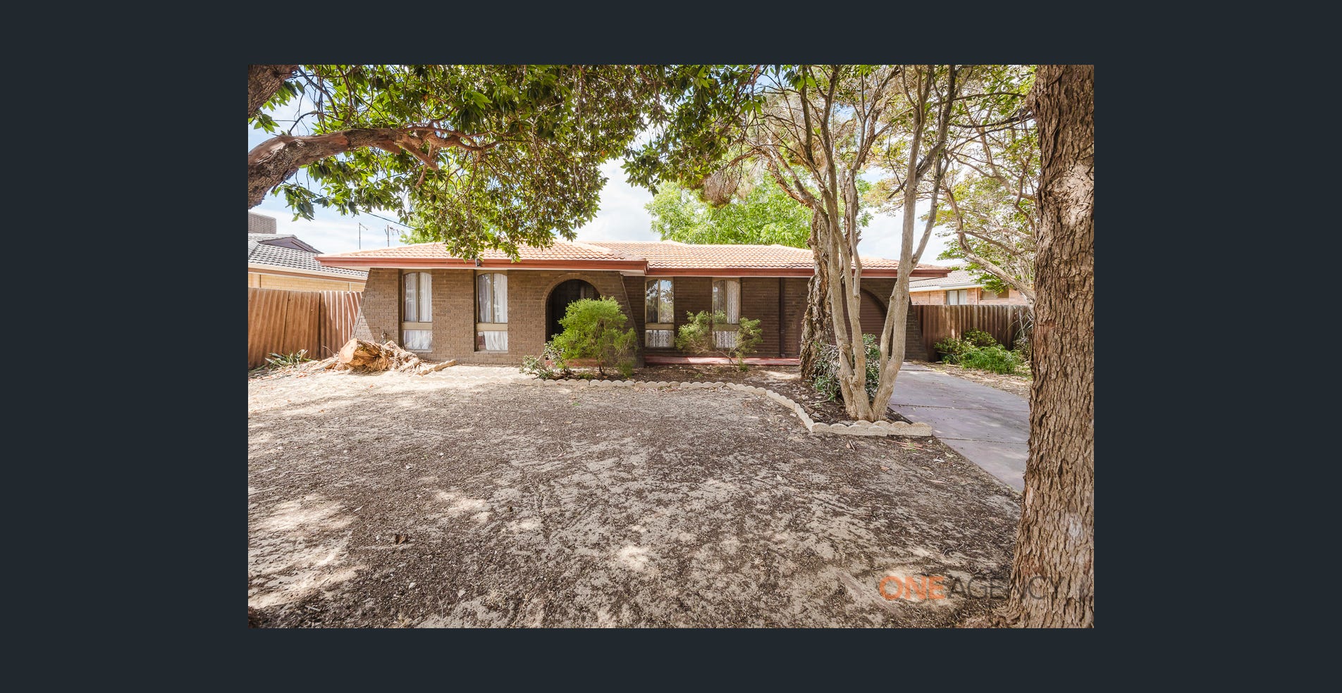 197 Seventh Road, Armadale, WA. A low brick house with a broad front garden, mature trees and a separate driveway along the side.